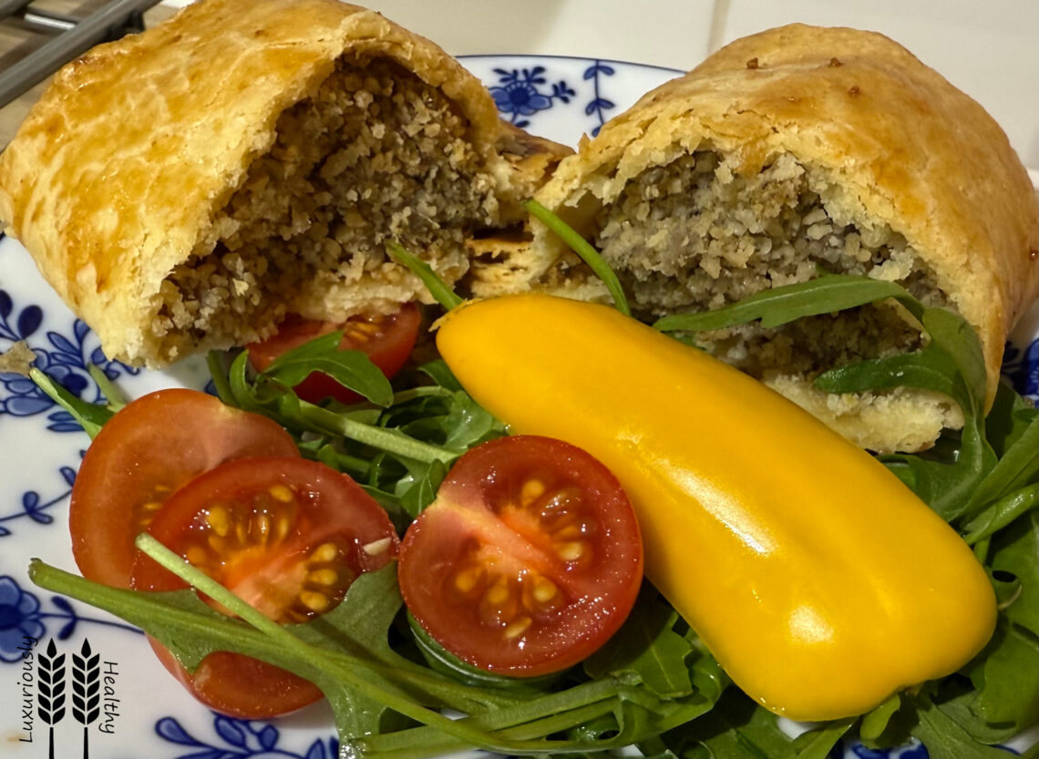 Cumberland sausage roll. Split and served with salad